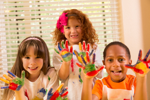 Children: Three childhood friends finger painting together.